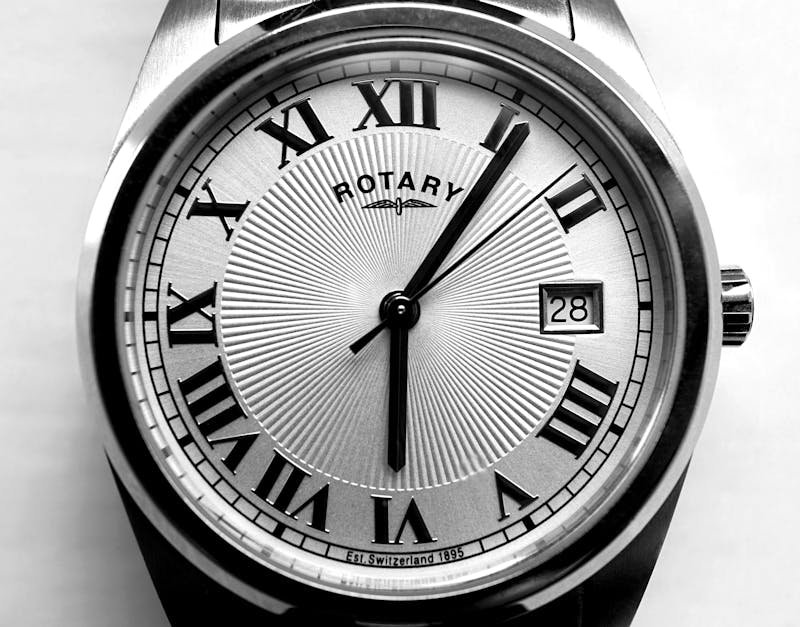 Silver Rotary watch face featuring Roman numerals, date display, and textured background.