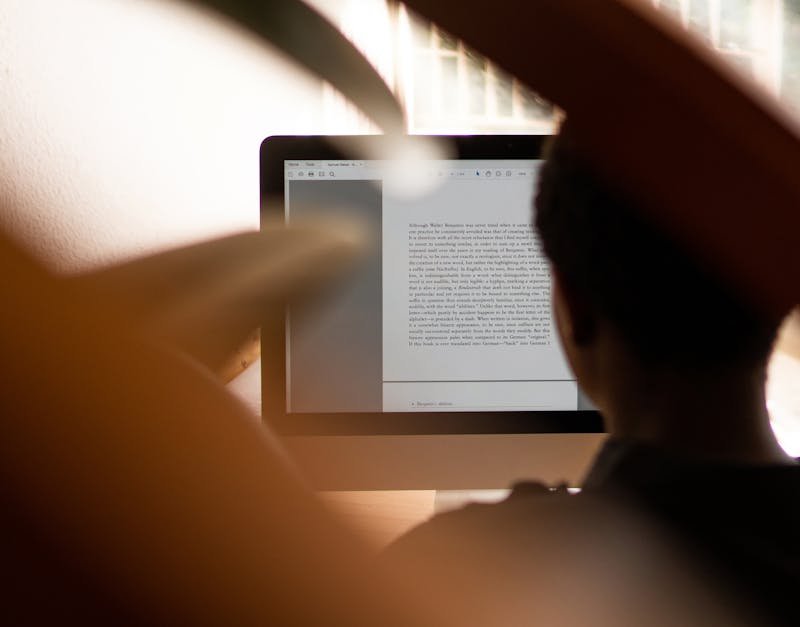 Silhouette of a person working from home on a computer, highlighting remote work lifestyle.