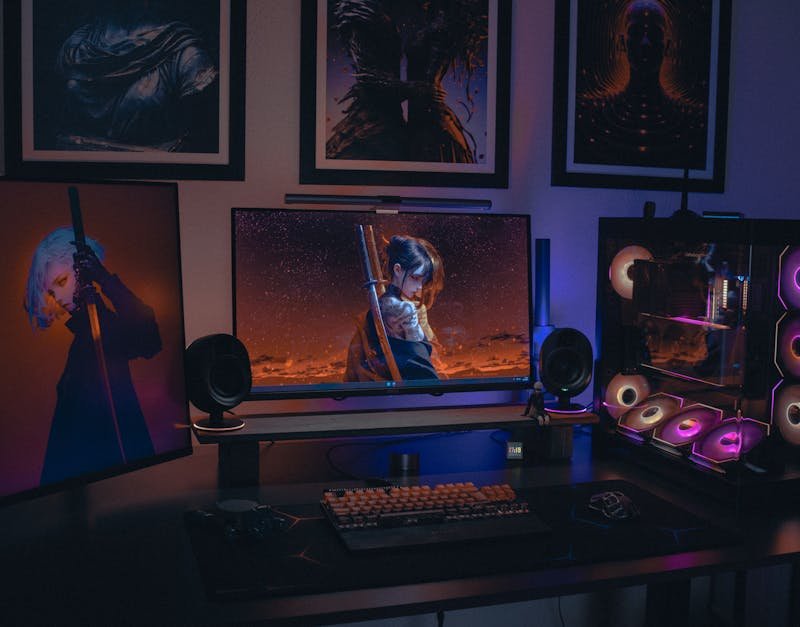 Colorful gaming setup featuring RGB-lit PC and anime artwork. Ideal for tech enthusiasts.