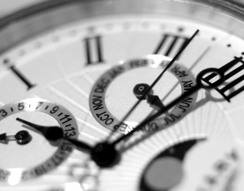Detailed black and white shot of an elegant watch face showcasing timekeeping elements.