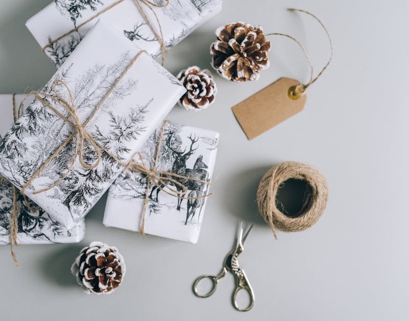 Beautifully wrapped Christmas presents with pine cones and twine in a minimalist style. Perfect for holiday inspiration.