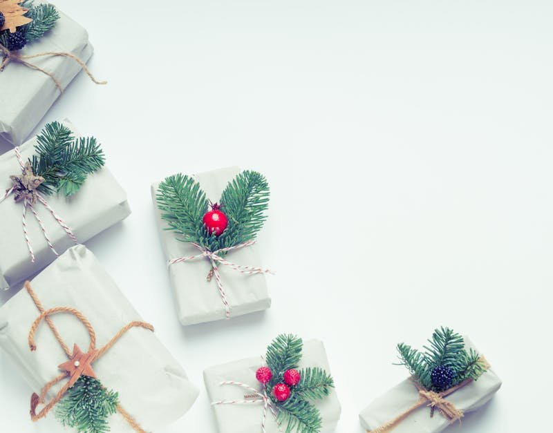 Minimalist Christmas gift boxes adorned with natural elements like pine branches and twine, perfect for holiday inspiration.