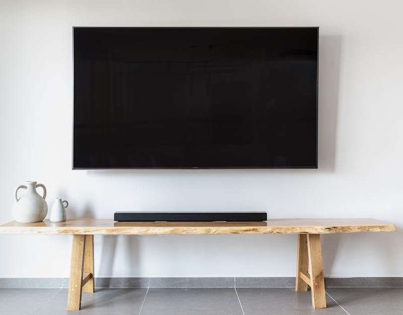 Stylish minimalist living room featuring a wall-mounted flat screen TV and wooden console.